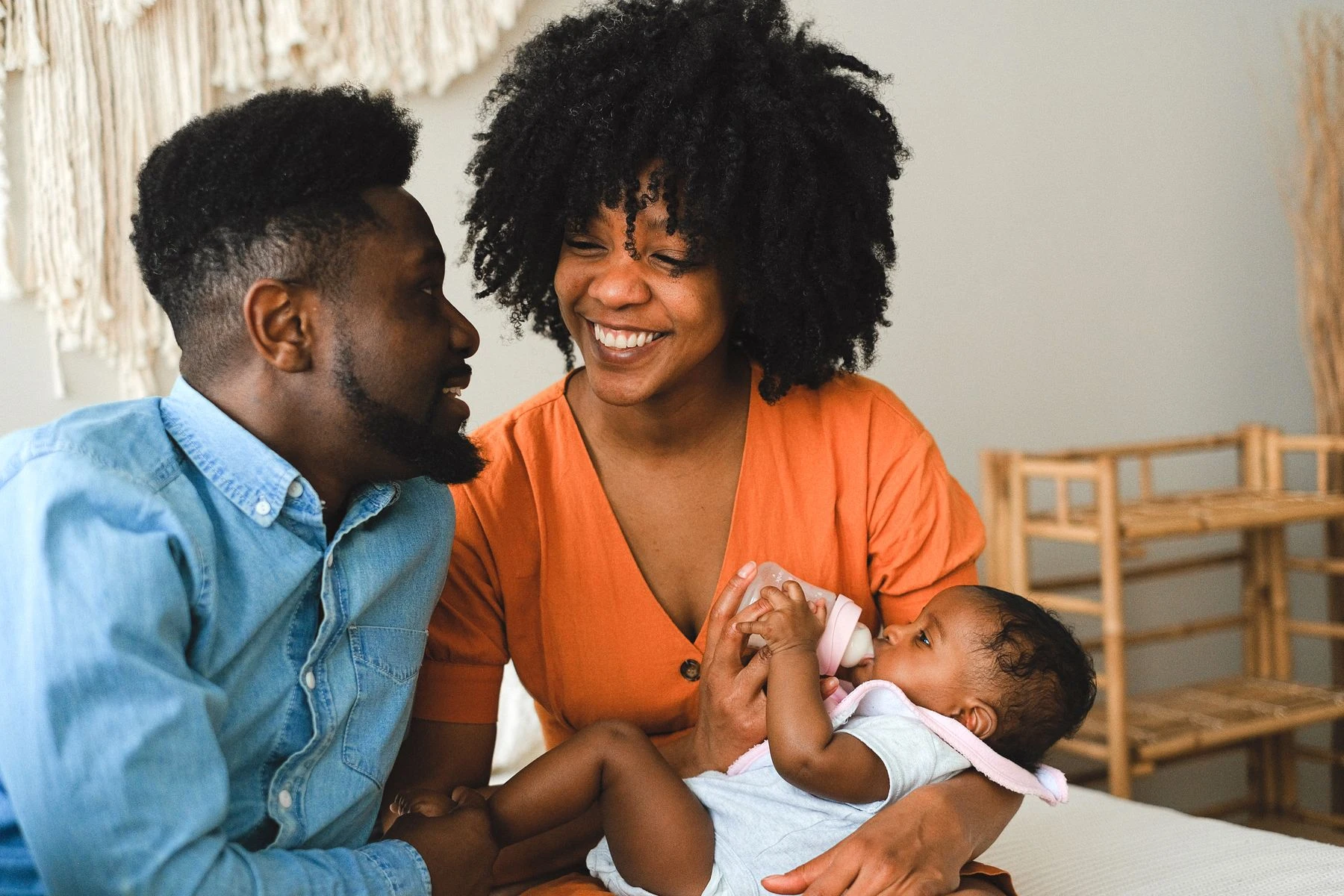 Black parents sharing a feeding moment with their newborn